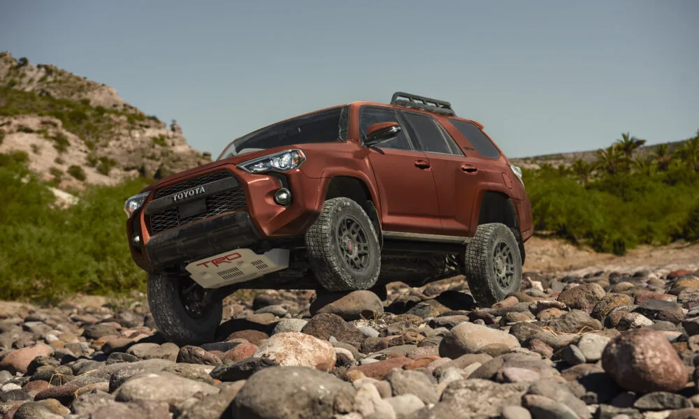 Stock 2024 Toyota 4Runner driving over a rocky trail